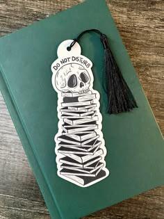 a bookmark with a skeleton on it and a tassel hanging from the front