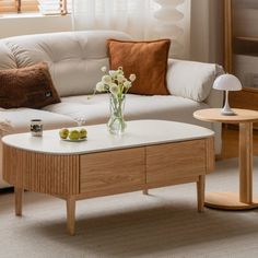 a living room with a white couch and coffee table in front of a large window