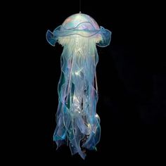 a jellyfish is floating in the dark with its head turned to look like it's swimming