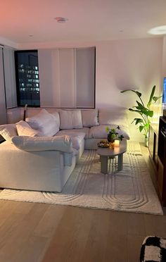 a living room filled with furniture and a flat screen tv on top of a hard wood floor