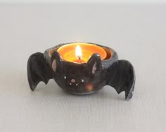 a candle with a bat shaped candle holder