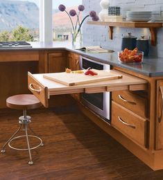 a kitchen counter with a cutting board on it and a stool in front of it