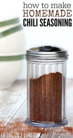 a jar filled with chili seasoning sitting on top of a wooden table