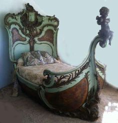 an old bed with ornate carvings on the headboard and foot board, in a corner