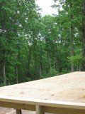 a wooden picnic table in the middle of a wooded area with no one around it