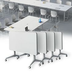 there are four tables and chairs in the room with one laptop on it's desk