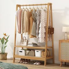 a wooden rack with clothes and shoes on it in a room next to a bed