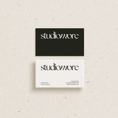 two business cards on top of each other with the word studiomore in black and white