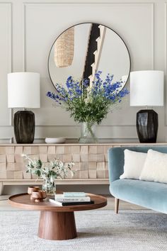 a living room filled with furniture and a round mirror