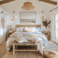 a large bed in a bedroom with white walls and flooring, along with wicker furniture