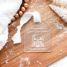 a wooden cutting board topped with a glass ornament that reads first christmas in our home