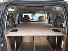 the back end of a van with its cargo compartment open and two seats folded down