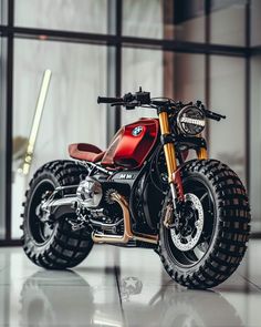 a red and black motorcycle parked in front of a window