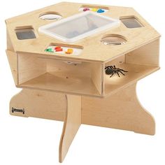 a wooden toy table with a spider on the bottom and an object in the middle