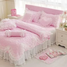 a pink bed with white ruffled bedspread and pillows