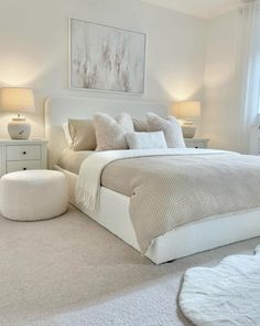 a white bed sitting in a bedroom next to two lamps on either side of the bed