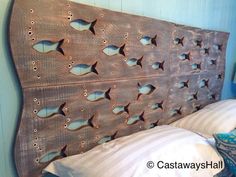 a wooden headboard with holes in the middle and fish on it's sides