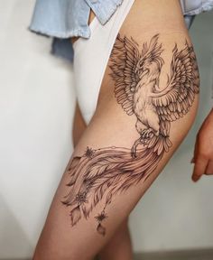 a woman's leg with a bird tattoo on the side of her thigh,