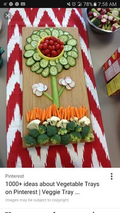 a table topped with vegetables and fruits on top of a wooden cutting board