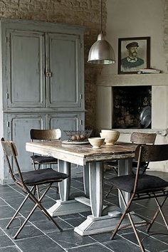 a dining room table with four chairs and an oven in the backround behind it