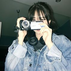 a woman holding up a camera to take a selfie in front of her face