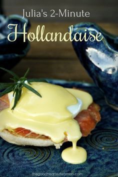 a blue plate topped with an open faced sandwich covered in hollandaise