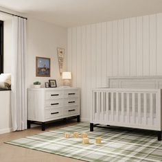 a baby's room is decorated in white and green colors with plaid rugs on the floor