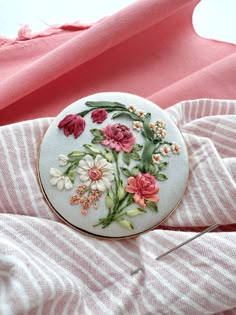 a white and pink object with flowers on it next to some threading spools