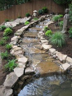 a small garden with rocks and water running through it