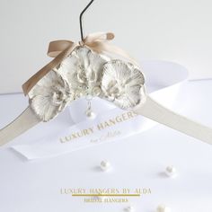 the bridal hanger is decorated with flowers and pearls on it's side