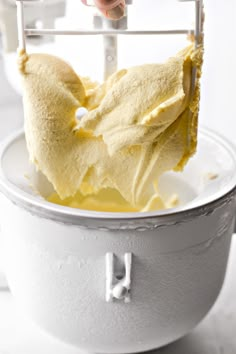 someone is using a spatula to mix batter into a cake in a white bowl