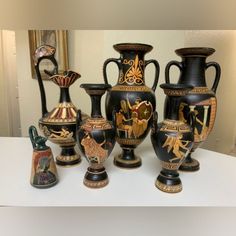 a group of vases sitting next to each other on a white counter top in front of a mirror