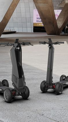 two black electric scooters sitting on the ground in front of a large building