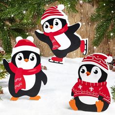 three penguins wearing hats and scarfs in the snow