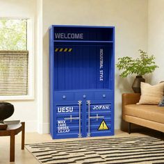 a living room filled with furniture and a large blue shipping container on the wall next to a couch