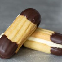 two chocolate covered cookies with white and brown icing