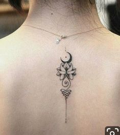 the back of a woman's neck with a flower and crescent tattoo on it