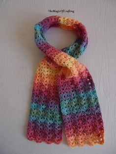 a multicolored crocheted scarf hanging on a wall