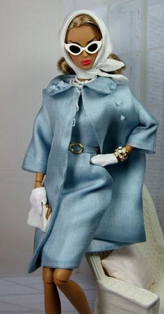 a doll in a blue coat and white gloves