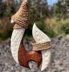 an ornament made out of wood and rope with two birds on it's back