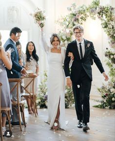 a bride and groom walking down the aisle