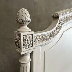 the headboard and foot board of a white bed with intricate carvings on it's sides