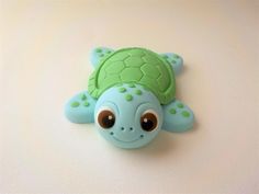 a close up of a small toy turtle on a white surface with one eye open