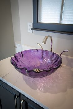 a glass bowl sink sitting on top of a counter