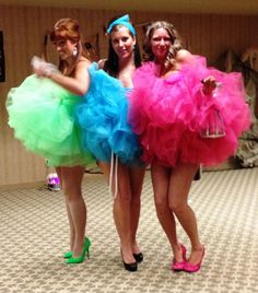 three women dressed in colorful dresses posing for the camera