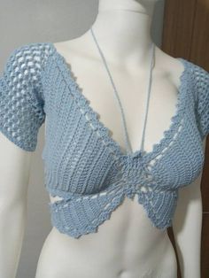 a white mannequin wearing a blue crochet top