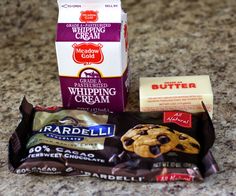 chocolate chip cookies, butter and whipped cream are on the counter next to each other