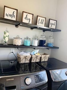 a washer and dryer sitting next to each other in a room with shelves on the wall