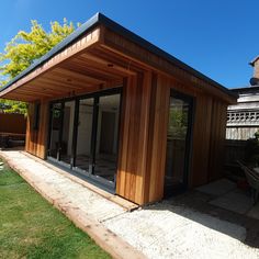 a wooden building sitting on top of a lush green field