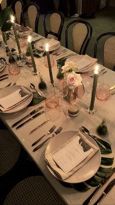 a table set with place settings and candles